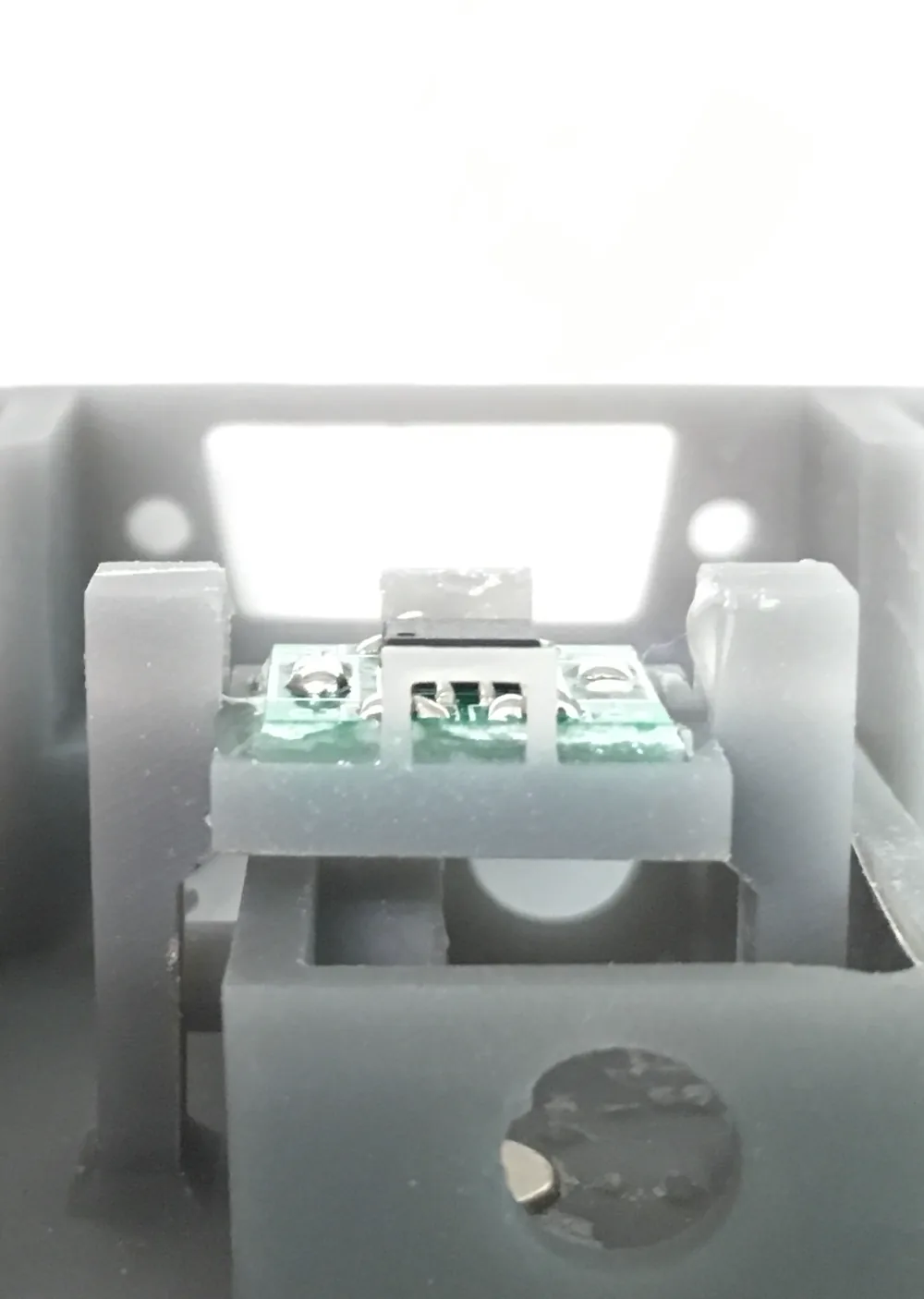 Image shows a close-up view of a 3D-printed object with a PCB embedded in it
